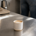 Kaffe kopper i keramik. Håndlavet stentøj med blå tern står på en stålbordplade