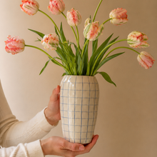 Keramik vase med tern holdes af en kvinde med tulipaner i.