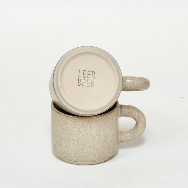Håndlavede keramikkopper med rund hank i beige og blank glasur, inklusiv LEEABAEK stempel.