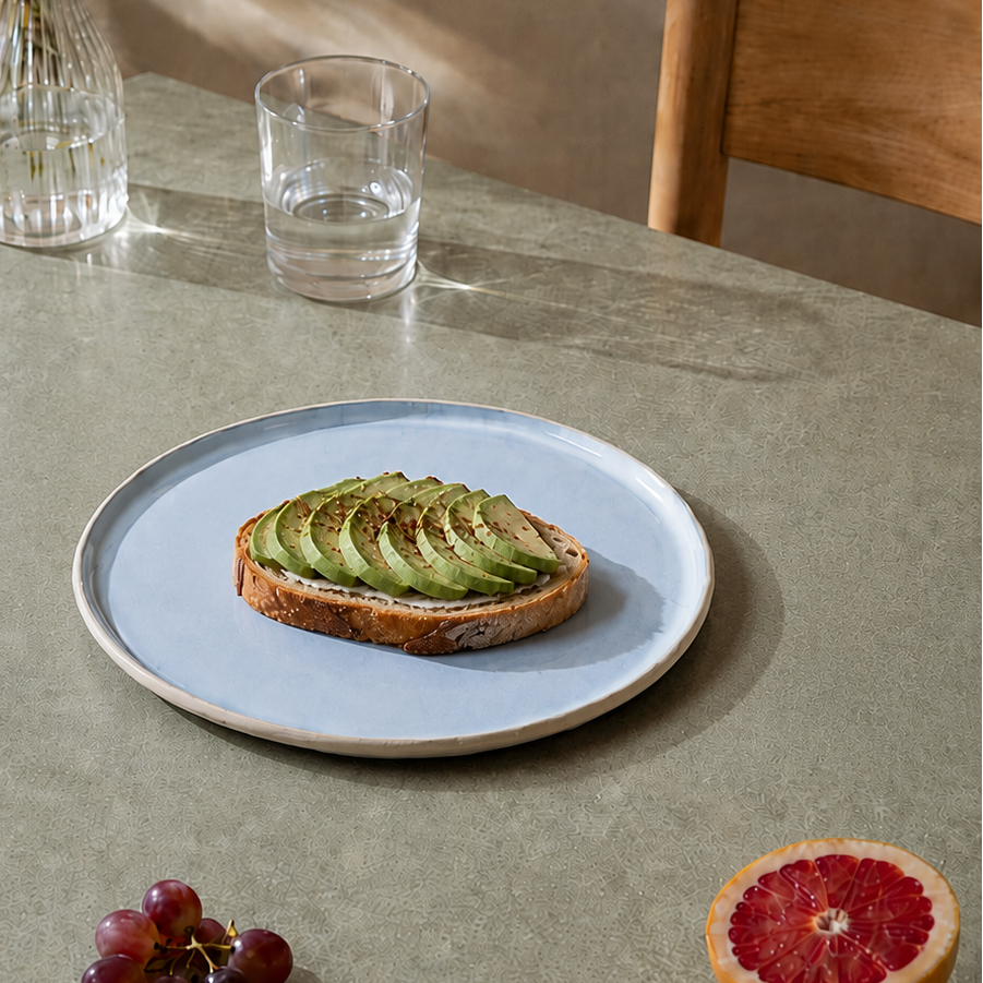 Stor keramik tallerkener lyseblå med avokadomad på et bord