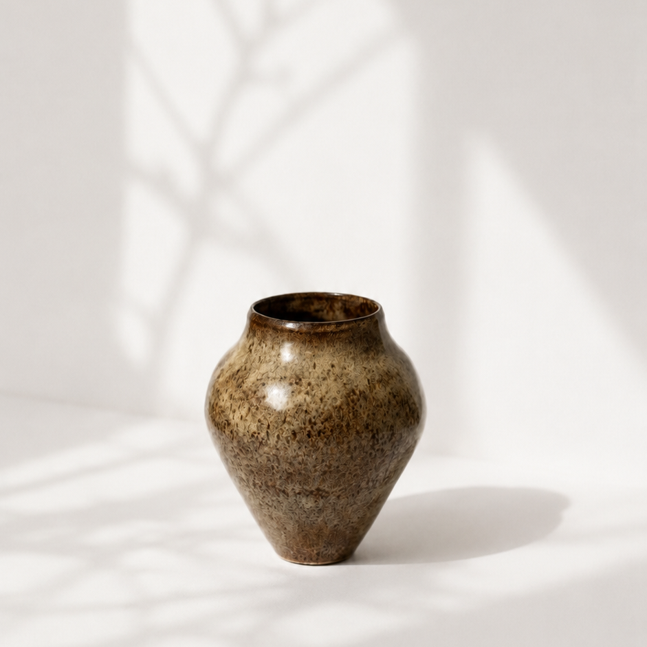 Brun keramikvase med blank glasur i beige nuancer. produktfoto med skygger. 