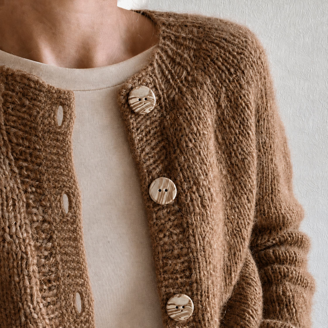 Kvinde med strikket cardigan med keramik knapper i beige og brun. 